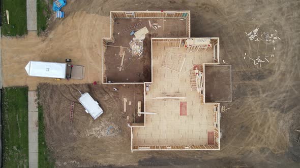 Top down view of new residential home construction site. Framing half complete. Lot backfilled.