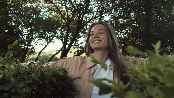 Happy Woman Walking Through Bushes alt