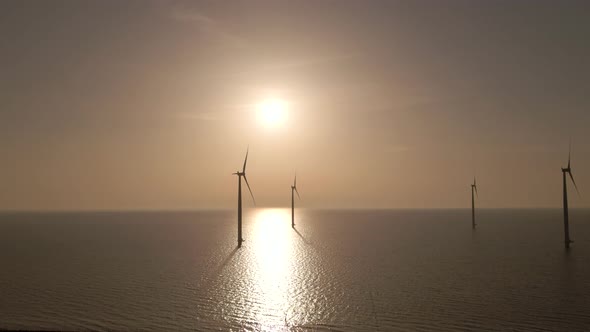 Flyover Wind turbines seascape and Bright sunlight Reflection on water surface alt