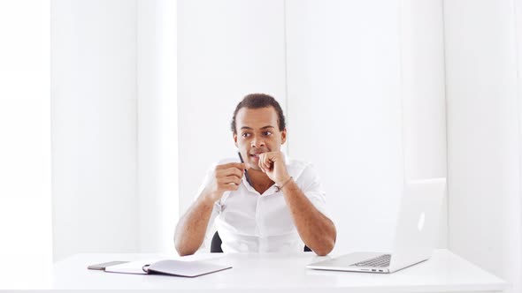 Young Successful Businessman Smiling Considering Rejoicing at Workplace alt