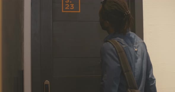 Young African American Man Knocking, Hugging Smiling Caucasian Woman, and Closing Door. Positive alt