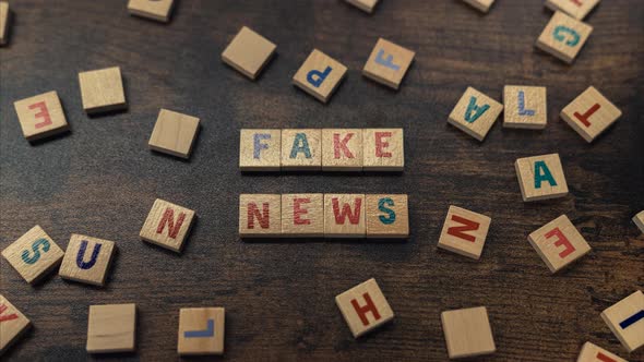 Fake News Concept  Phrase Spelled From the Wooden Cubes on Tabletop  Zooming Shot alt