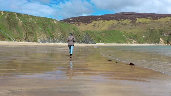Lady Walking on the Beautiful Beach at Malin Beg in County Donegal  Ireland alt