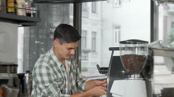 Handsome Cheerful Male Barista Preparing Coffee for Clients at His Cafe