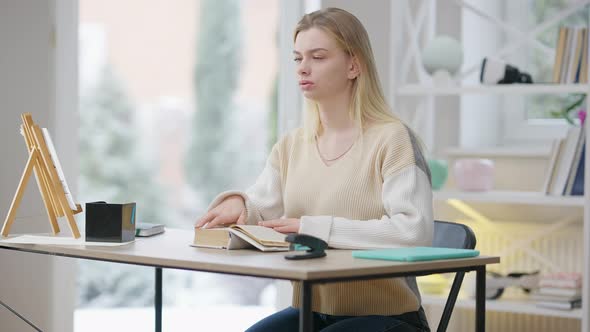 Concentrated Blind Young Woman Reading Braille Book at Home alt