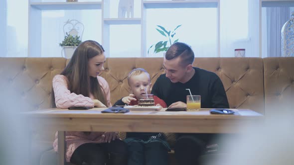 Tired Child Lies on Father Hands Stands Up and Drinks alt
