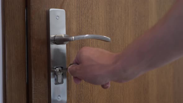 Opening a locked wooden interior door. Turning the key in the lock.