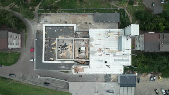 Top Aerial View of a Construction Site on the Roof of a Tall Building alt