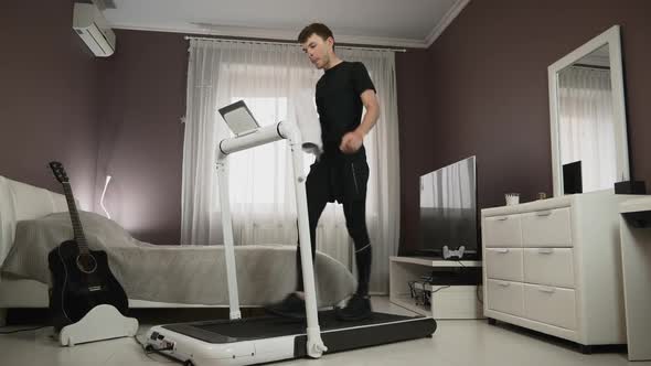 Athlete is doing intense cardio fitness workout at home on treadmill alt