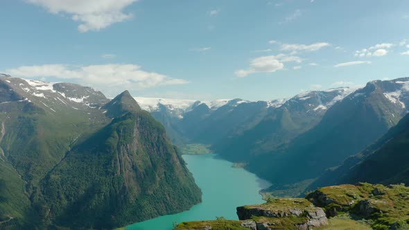 Scenic Mountain Views Near Olden With Calm Blue Waters Of Lake In Norway. - aerial alt