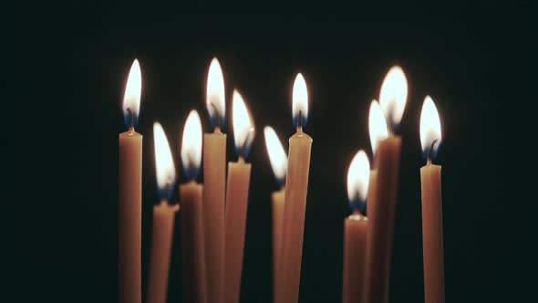 Candles Are Burning in the Spacious Room and Go Out. Black Background alt