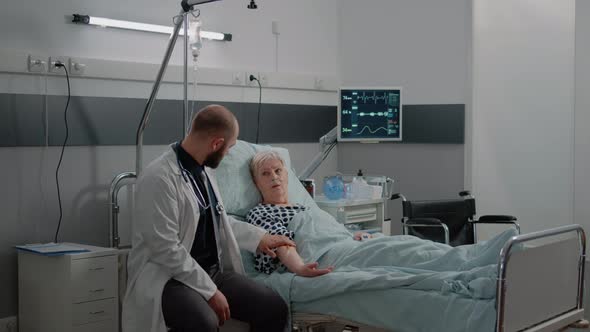 Doctor and Nurse Checking on Elder Patient in Hospital Ward Bed alt