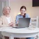 A Social Worker Helps an Old Lady Talk to Her Family Using a Laptop - VideoHive Item for Sale