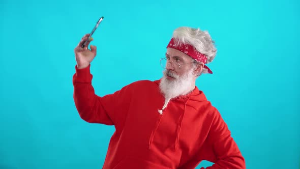 Grayhaired Adult Man in a Red Hoodie Takes a Selfie on a Smartphone Caucasian Man Takes Pictures of alt