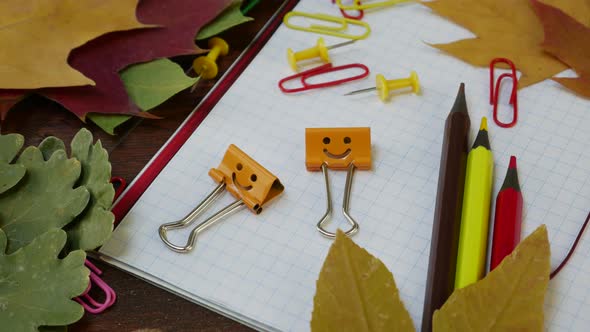 Smiles Yellow Binder Clips on Fallen Maple Leaves and School Office Supplies