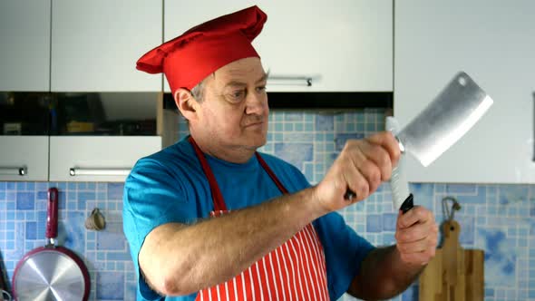 Senior Adult Cook Caucasian Ethnicity in Chefs Hat Sharpens Knife on Knife on Domestic Kitchen alt