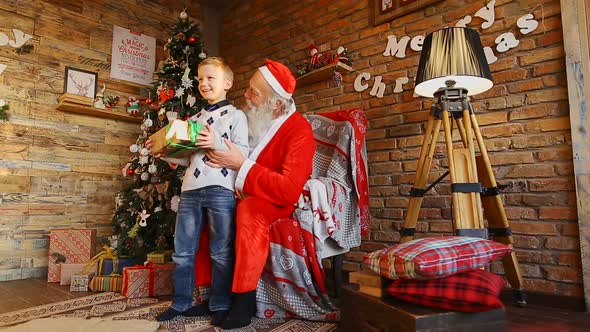 Santa Claus Presents Gift To Happy Boy