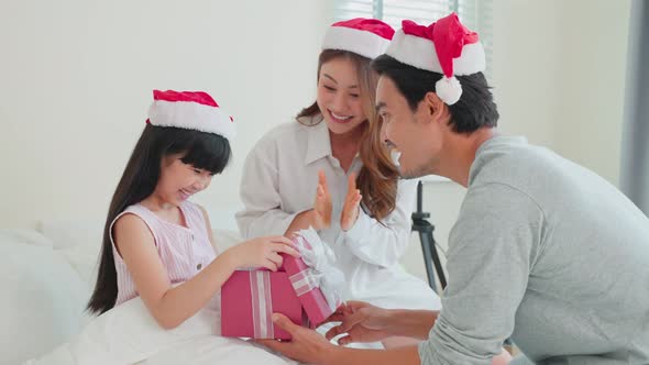 Portrait of Asian little daughter receive present gift box from parent feel happy and excited. alt