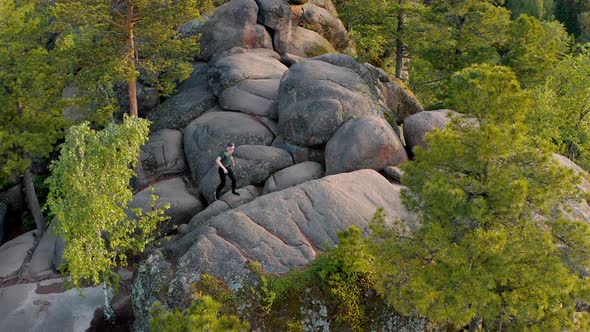 The traveler is climbing on the top of the wild mount The Krasnoyarsk Stolby alt