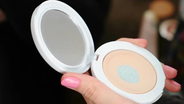  Woman's Hands with Cosmetic Powder and Mirror Doing a Makeup Using a Brush.