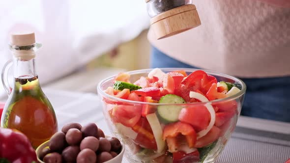 Greek Salad Preparation Series Concept  Woman Peppers Chopped Vegetables in a Glass Bowl alt