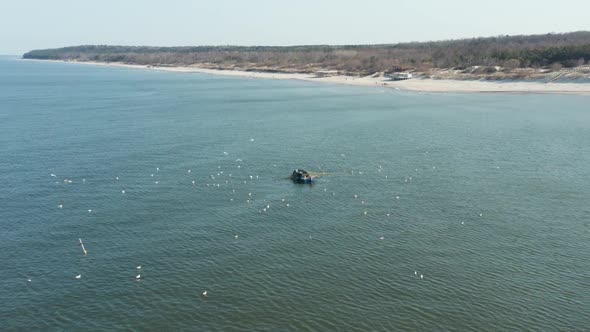 AERIAL: Fishermans Catching Fish Near the Shore in Klaipeda on a Sunny Day alt