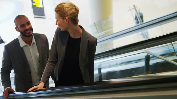 Business people interacting on an escalator alt
