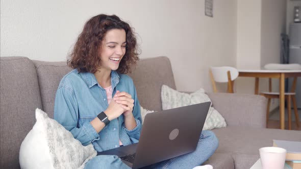 Hispanic Young Woman Using App on Laptop Computer While Sitting at Home alt