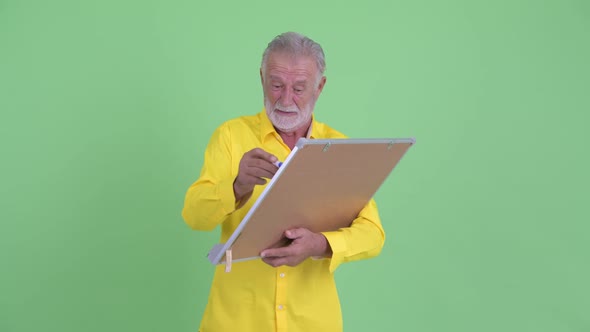 Funny Senior Bearded Businessman Holding White Board with Help Sign alt