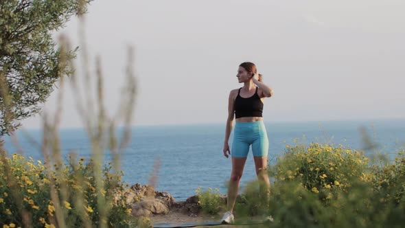 Sports Outdoors  a Woman Standing on Yoga Mat By the Sea alt