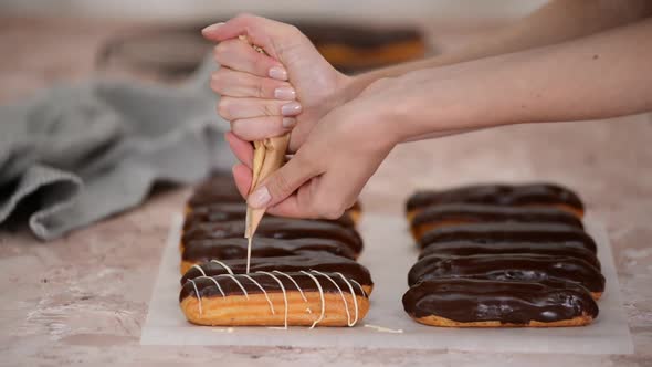 Pastry Chef Pours White Chocolate on French Eclairs