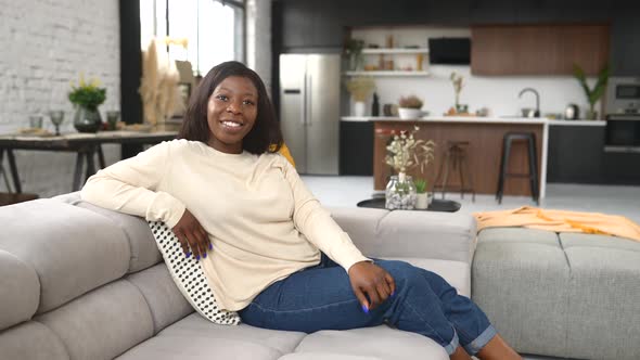 Healthy Woman Sitting on the Pure Comfortable Sofa at Modern Apartmen