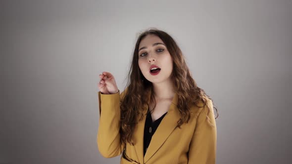 Portrait of Young Irritated Woman Making Bla Bla Sign By Her Hand on White Background in a Slowmo alt