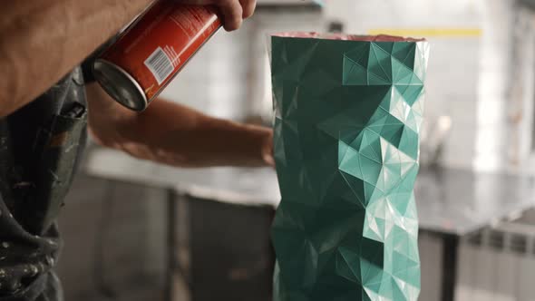 Male craftsman burns his product with a gas burner in the workshop alt