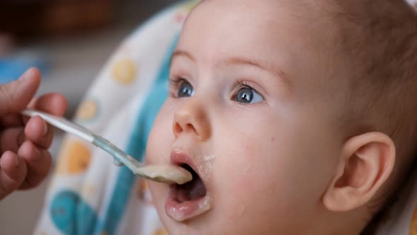 Close Up of the Face of a Small Child Eating From a Spoon