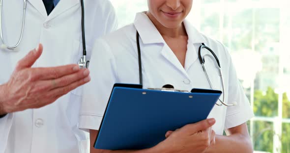 Happy doctors looking at clipboard alt