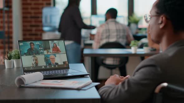 African American Man Talking to Colleagues on Videocall Meeting alt