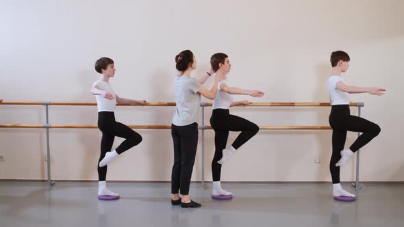 Teacher Choreographer Helps and Controls Group of Boys Students in Ballet School