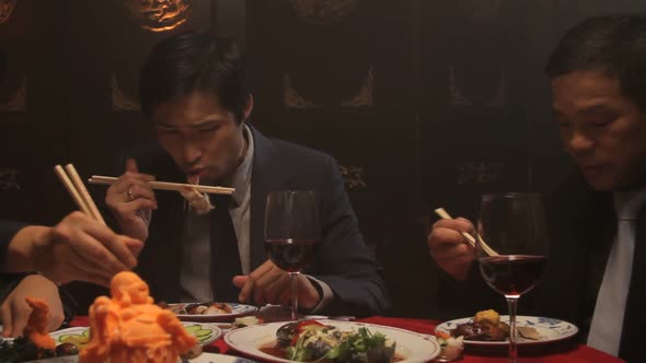 Businessmen eating in Chinese restaurant alt