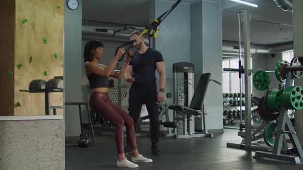 Female Exercising with Trx Fitness Straps at Gym alt