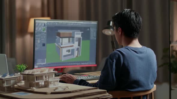 Asian Male Engineer Rotate 3D House While Working On A Desktop At Home alt
