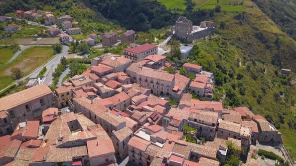 Aerial View of Medieval City on Hill Overlooking the Sea Coast Village and Mountains, Sunny Day