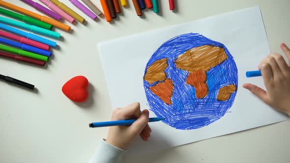 Child Painting Earth and Putting Heart Sign, Peace All Over World, Concept alt