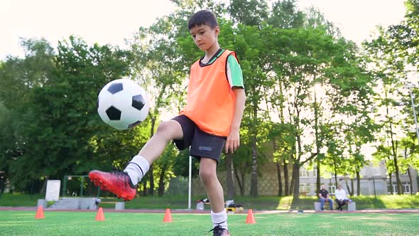 Boy In Football Uniform With Orange Vest Which Stuffing The Ball With Feet Durung Training By Sergii Kozii