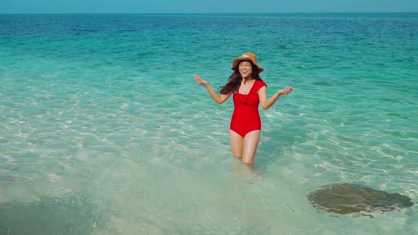 slow-moiton of cheerful young woman playing water splash in the sea beach alt