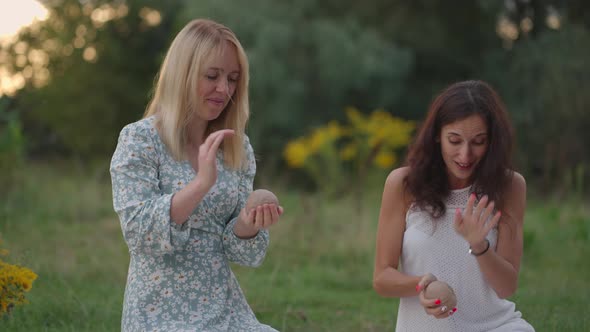 A Group of Young Women Sculpts Out of Clay in Nature in a Park in an Open Space alt