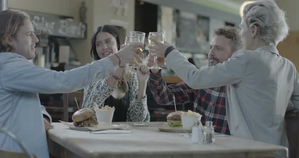 Men and women enjoying wine and beer while sitting in pub