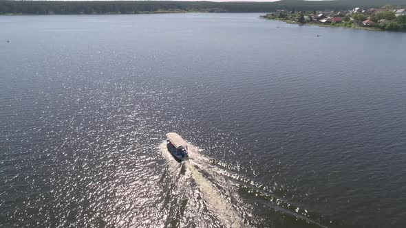 Aerial view of pleasure boat with people floats on the pond in provincial city 06 alt