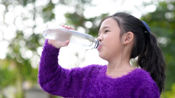 Beautiful Asian Girl Drinks Water From A Bottle Outdoor alt