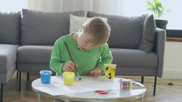 Boy with Down Syndrome Drawing at Home
